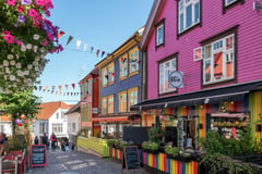 Colorful wooden buildings and outdoor dining area in Bergen's historic Bryggen district.