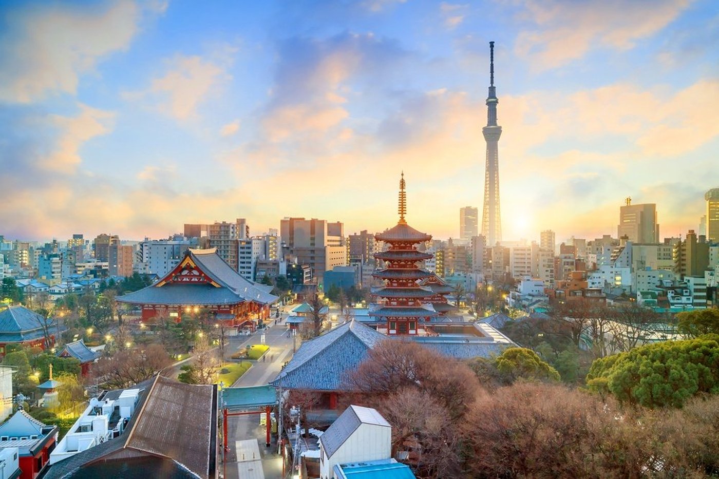 Tokyo skyline at sunset featuring traditional pagoda and modern Tokyo Skytree tower.