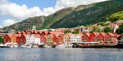 Colorful wooden buildings and boats along the historic Bryggen wharf in Bergen, Norway.