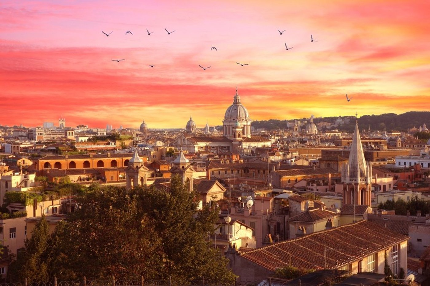 Rome cityscape at sunset with dramatic orange and pink sky, domed basilica, and birds flying overhead.