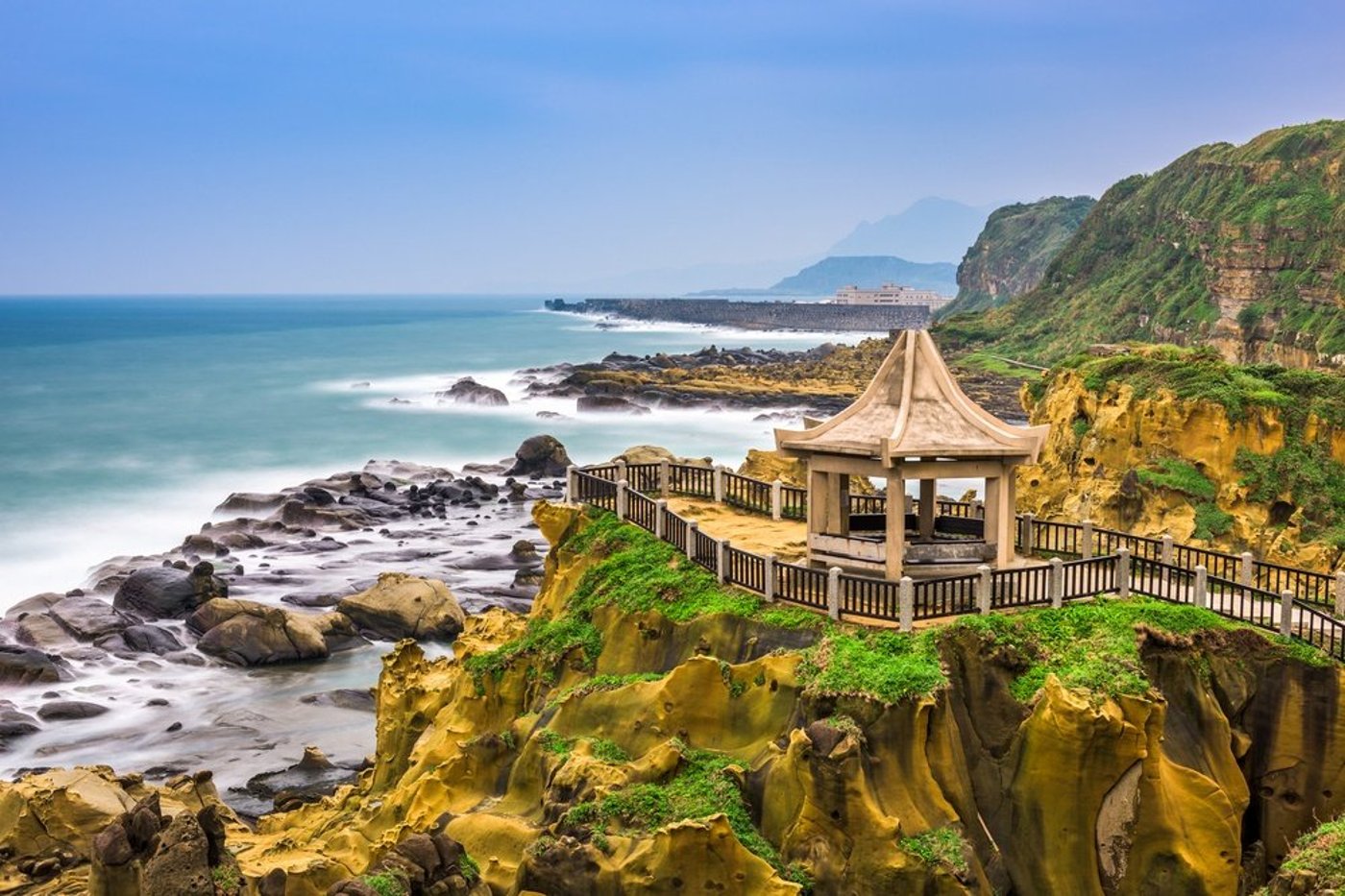 Coastal temple pavilion overlooking rocky shoreline and ocean in Taiwan.