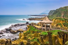 Coastal temple pavilion overlooking rocky shoreline and ocean in Taiwan.