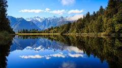 Snow-capped Southern Alps reflected perfectly in the still waters of Lake Matheson.