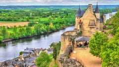 Aerial view of a medieval French château overlooking the Loire River with surrounding green countryside.