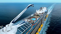 Aerial view of a cruise ship at sea showing the top deck with pools and the North Star observation capsule.