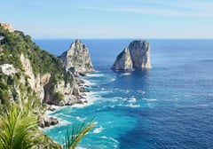 The Faraglioni rock formations rising from the turquoise waters off the coast of Capri.